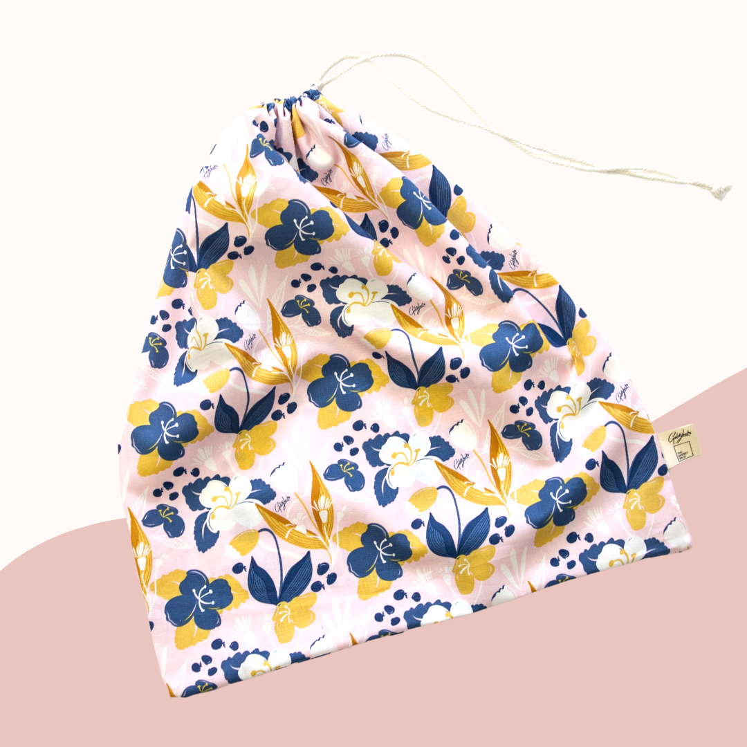 Floral-patterned bag with blue and yellow flowers on a light pink background
