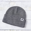 Gray beanie with a logo on a light wooden surface