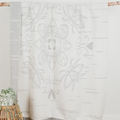 The Birch Bark Reversible Blanket by Mini Tipi, featuring a delicate white birch bark-inspired pattern on a grey background, hanging from a wooden rod. This reversible blanket is available in Ottawa, Ontario, Canada.