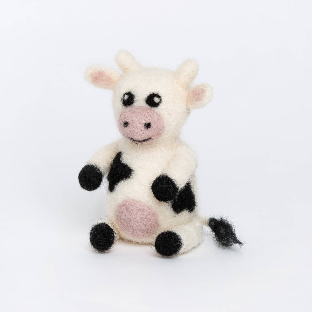Small cow plush toy with black spots on a white background