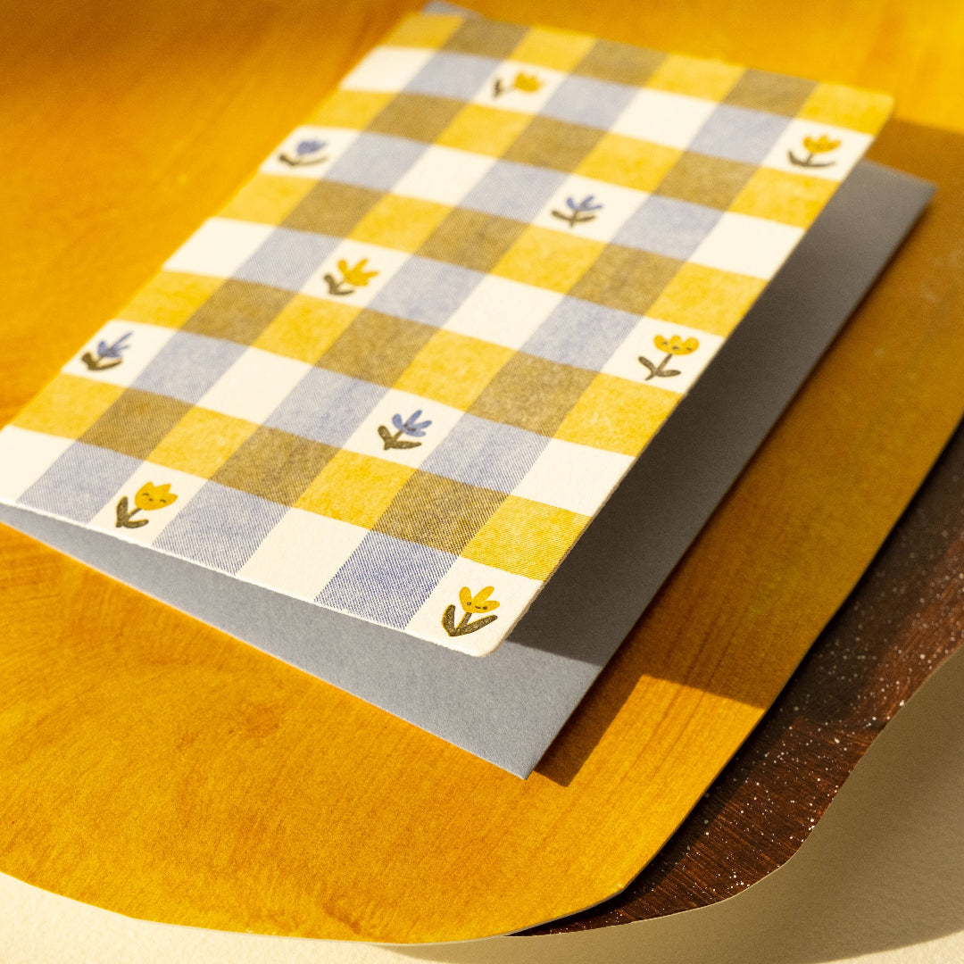 Checkered paper with floral patterns on a wooden surface