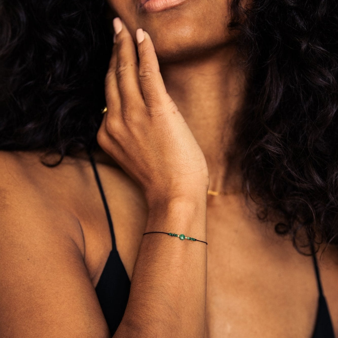 Woman with hand on face against a dark background