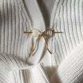 Brass Bow Hairpin close up on white sweater background
