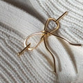 Brass Bow Hairpin close up on white sweater background