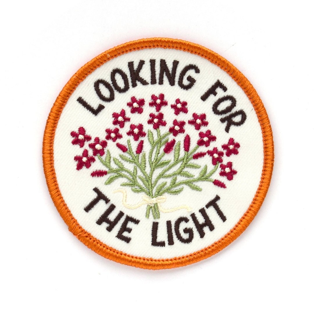 Patch with embroidered flowers and text 'Looking for the Light' on a white background