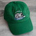 Green cap with a cat graphic and text on a marble surface