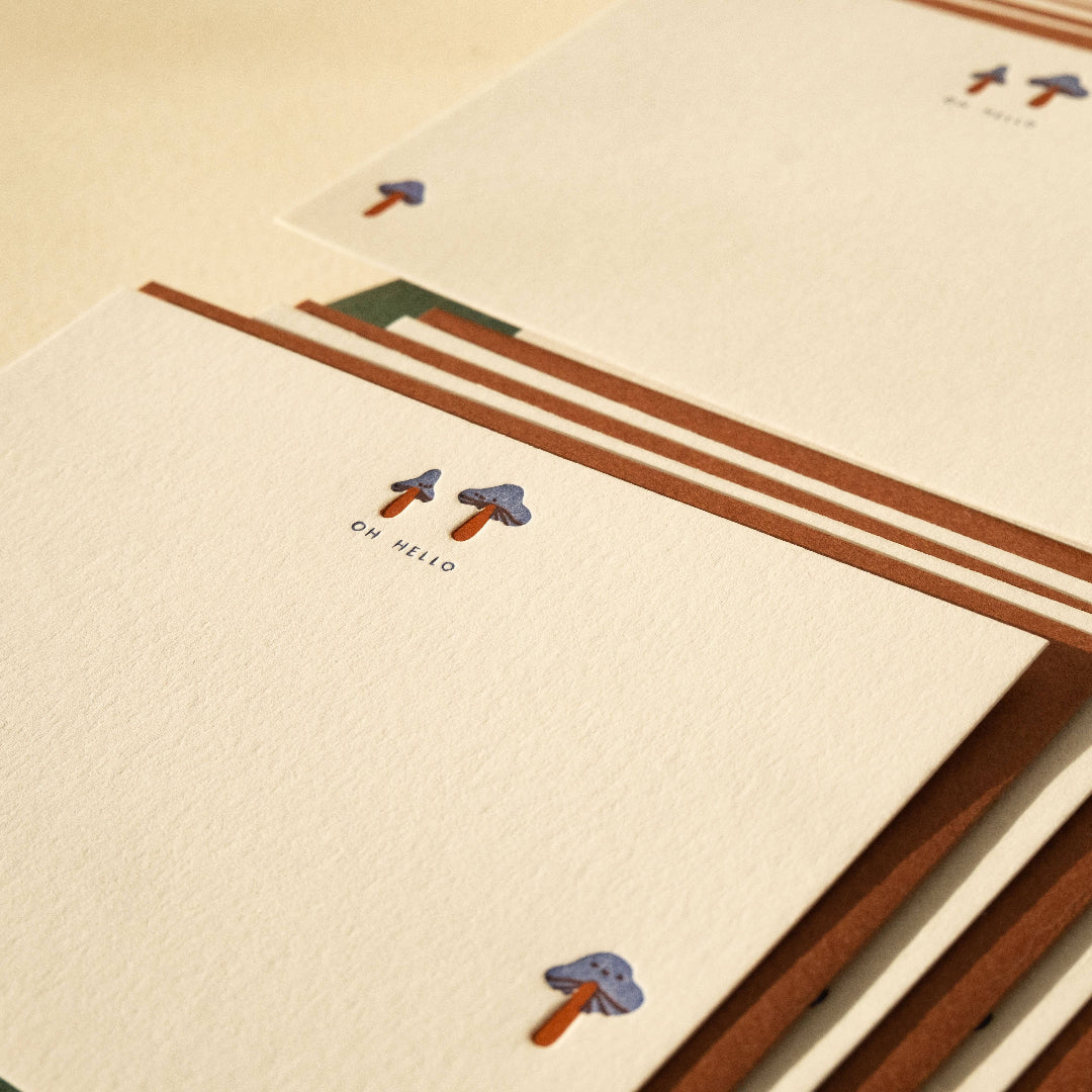 Notebook with decorative elements and 'OH HELLO' text on a beige background