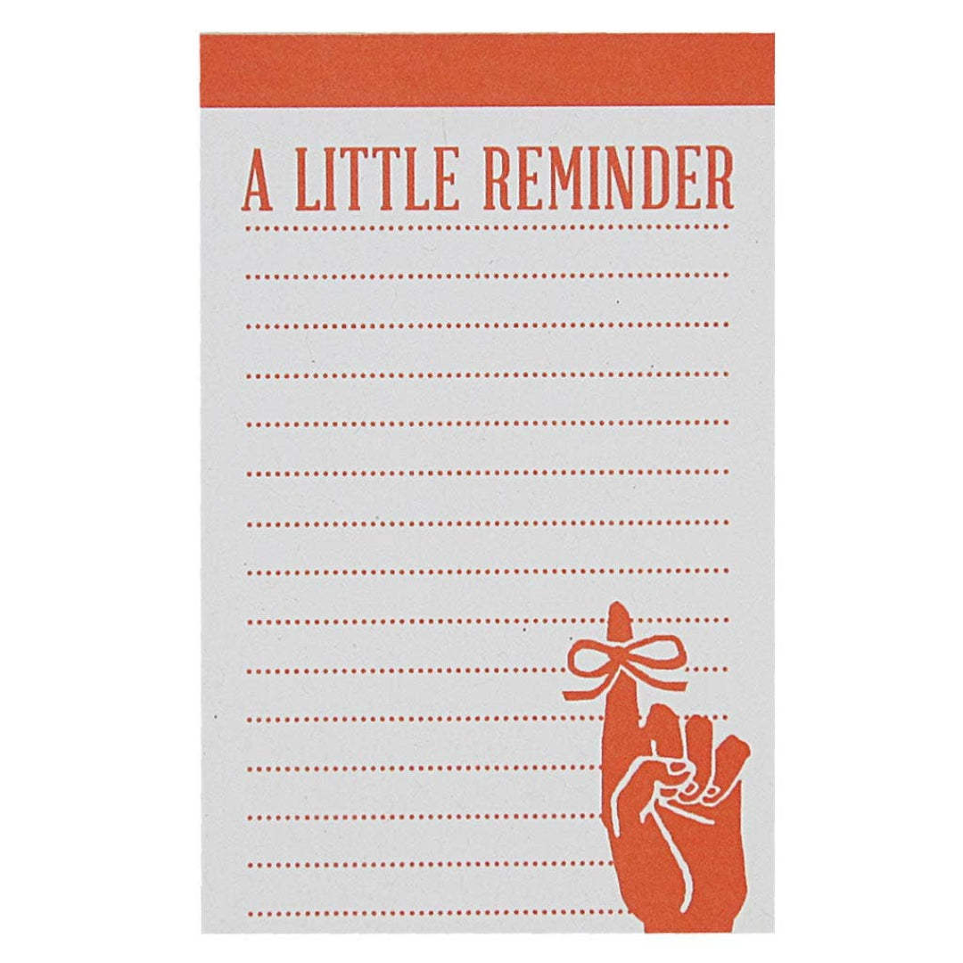 A small notepad with an orange header that reads "A LITTLE REMINDER" and a graphic of a hand with a string tied around its index finger at the bottom right. The rest of the notepad has dashed lines for writing notes.