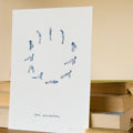 Sheet of paper with blue yoga pose illustrations on a beige background