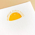 White towel with a yellow sun graphic and 'Hello Sunshine' text on a beige background