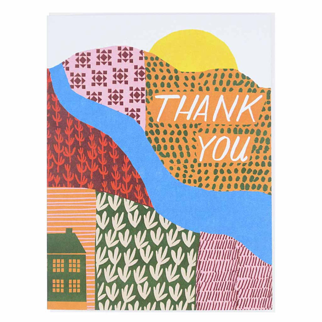 A thank you card with a colourful, abstract landscape design featuring hills, a river, and a house. The words "THANK YOU" are in white text on an orange patterned hill under a yellow sun.