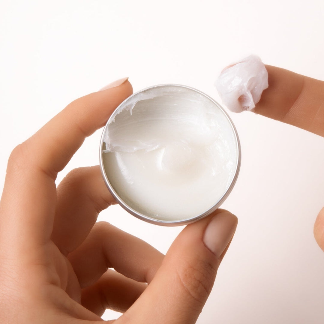 A small, open, silver metal tin of Everist's "The Fragrance-Free Conditioner Concentrate Mini," revealing a translucent, gel-like product inside. The tin's lid is propped against the base, and text on the side indicates it's dermatologist-developed and contains 20ml of product.