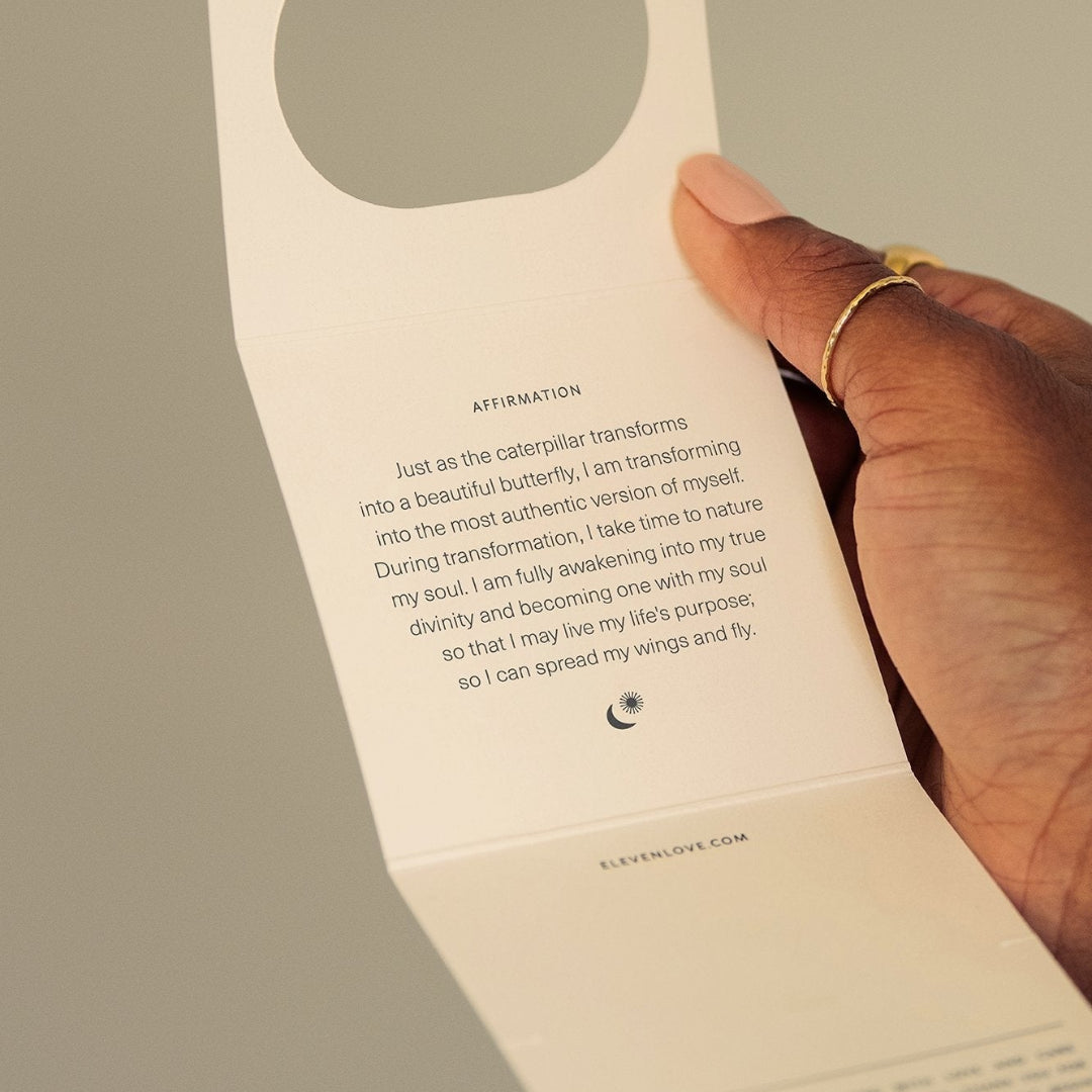 Hand holding a card with text and a circular cutout on a neutral background