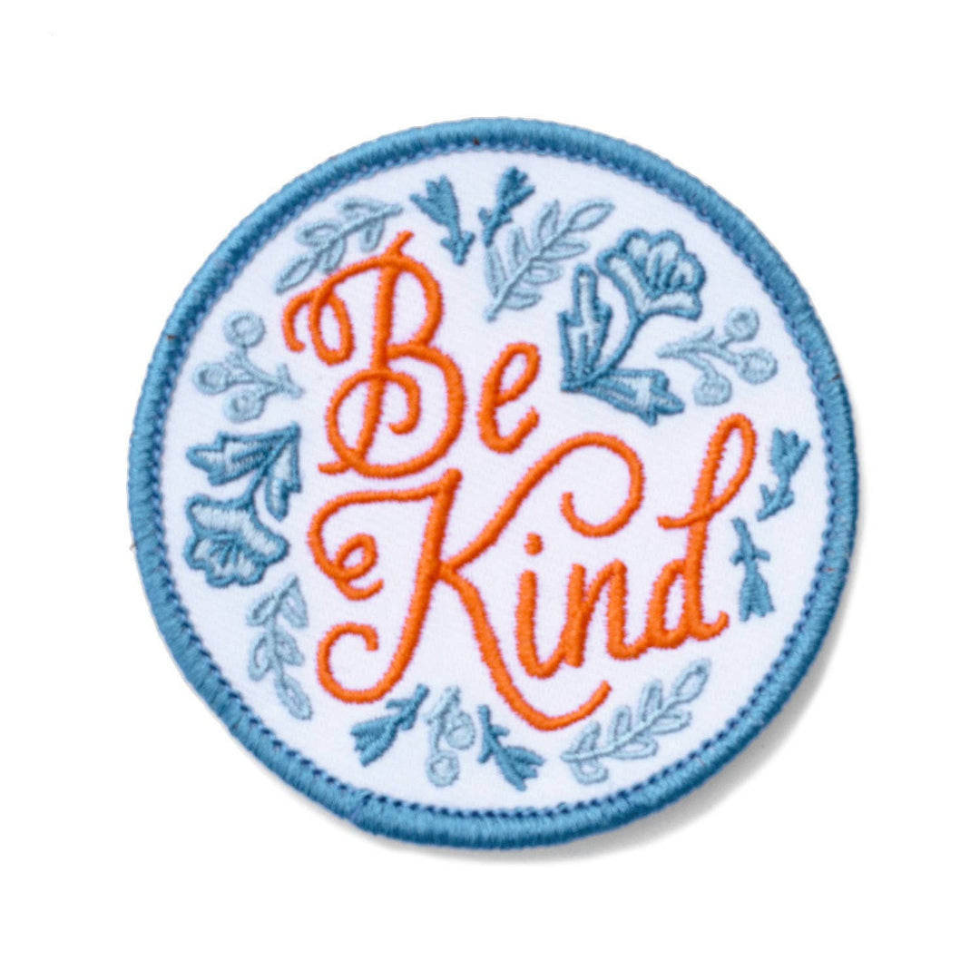 Circular patch with 'Be Kind' text and floral designs on a white background