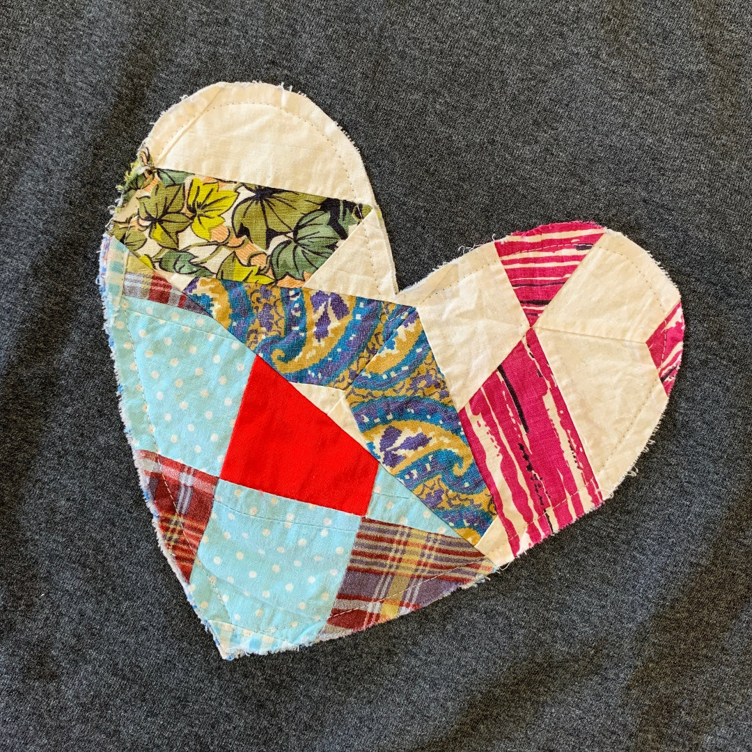 Heart-shaped patch with quilted design on a dark gray shirt